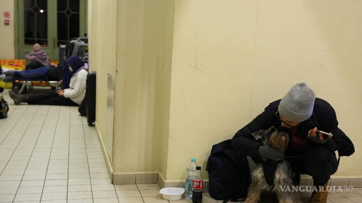 $!Una mujer ucraniana acaricia a su perro en la estación del metro habilitada como refugio.