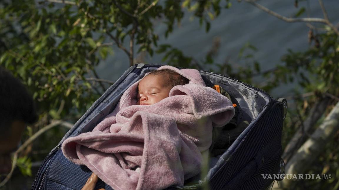 $!Migrantes cruzan el Río Bravo para entrar a Estados Unidos, con un bebé dentro de una maleta, vistos desde Matamoros, México, el 10 de mayo de 2023.