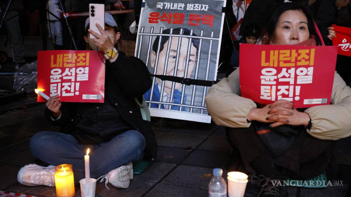 $!Miembros de grupos cívicos y de la Confederación Coreana de Sindicatos (KCTU) sostienen velas y carteles que dicen “¡Yoon Suk Yeol, dimite por traición!”.