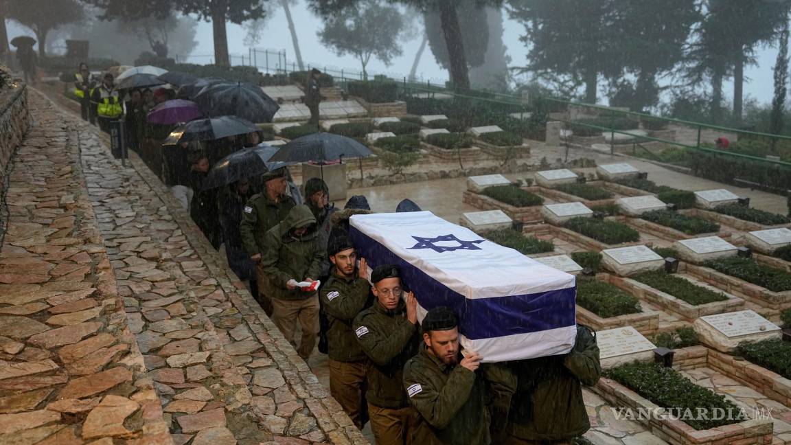 $!Soldados israelíes cargan el ataúd del reservista Elkana Vizel en su funeral en el cementerio militar Monte Herzl en Jerusalén, el martes 23 de enero de 2024.
