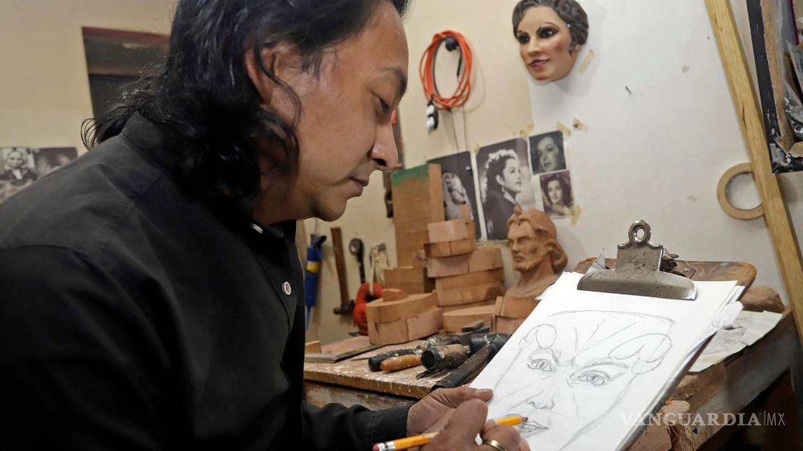 $!El escultor Adrián Becerra mientras trabaja en su taller de máscaras talladas en madera artesanal, en la ciudad de Puebla (México). EFE/ Hilda Ríos