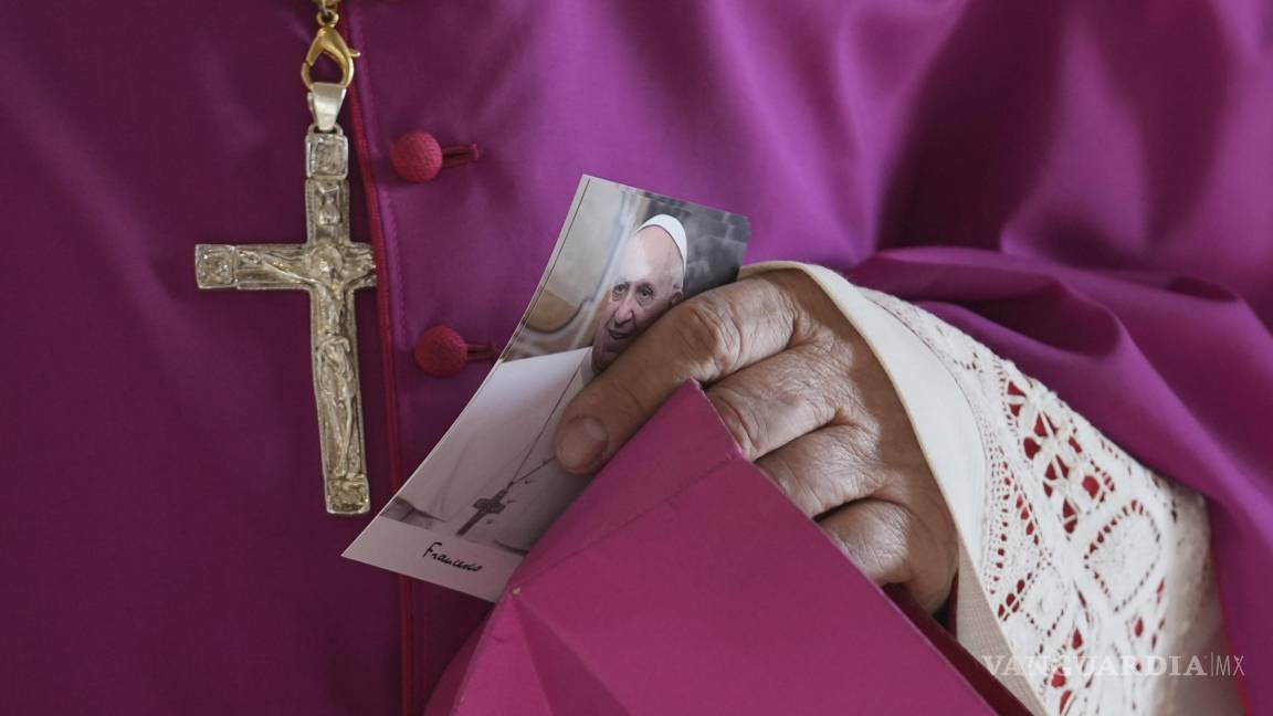$!Un prelado sostiene una foto del papa Francisco a su llegada a la basílica de San Pedro en el Vaticano donde el cuerpo del pontífice permanecerá tres días.