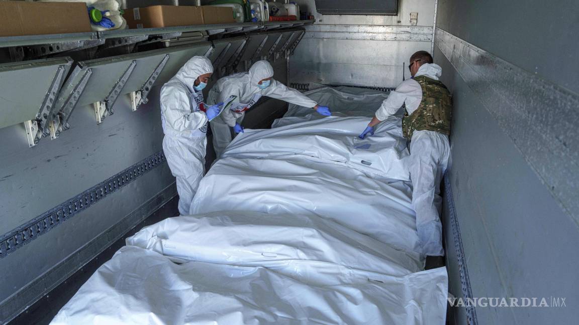 $!Trabajadores del Comité Internacional de Cruz Roja en la región ucraniana de Sumy inspeccionan bolsas de cadáveres con soldados rusos, el 31 de mayo de 2024.