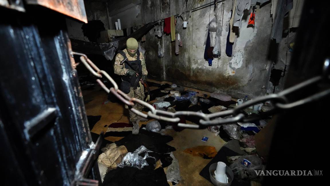 $!Un miembro de las fuerzas de seguridad del nuevo gobierno provisional sirio inspecciona una celda del centro de detención de la Sección Palestina en Damasco.