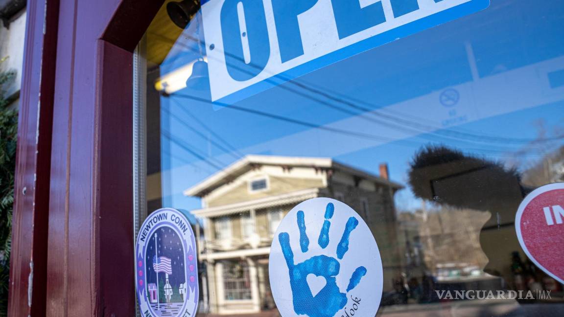 $!Vista de una pegatina con la huella de una mano y la fecha de la matanza de Sandy Hook en la entrada de una tienda en Newtown, Connecticut.