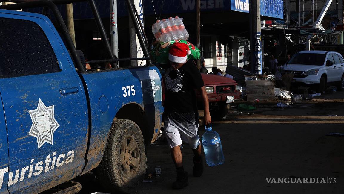 $!Fotografía que muestra a una persona mientras con objetos saqueados una tienda de autoservicio por el paso del huracán Otis en Acapulco, en Guerrero (México).