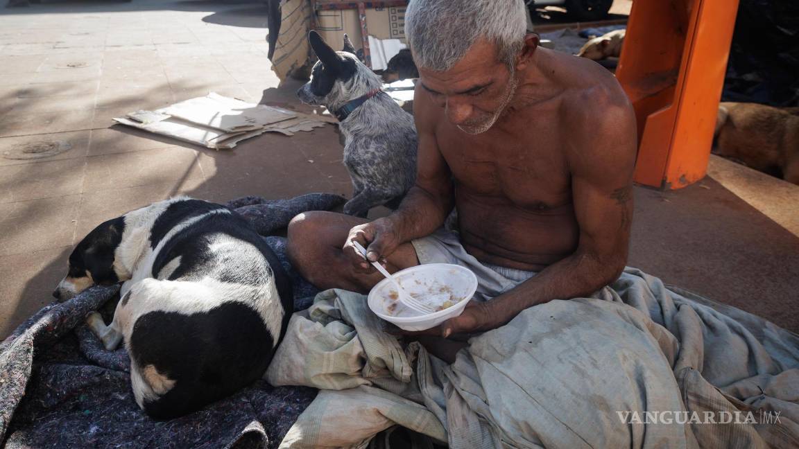$!Un hombre come en una calle, en el centro de la ciudad, en Sao Paulo (Brasil).