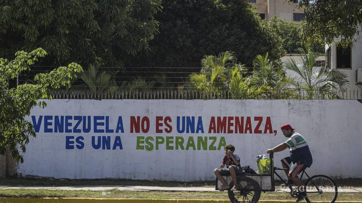 $!Personas transitan en bicicleta frente a un mural en Maracaibo, Venezuela.