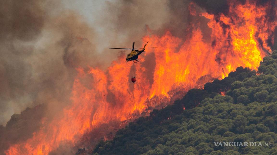 $!Un helicóptero trabaja en las tareas de extinción del incendio declarado este mediodía en el paraje El Higuerón de Mijas (Málaga) en España