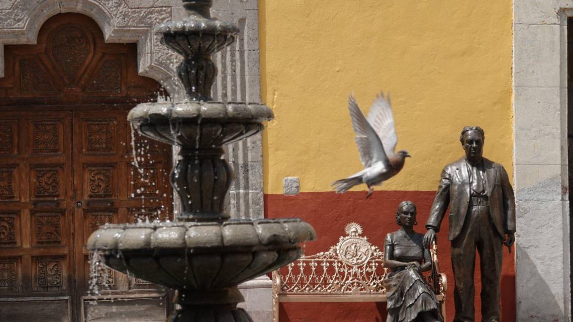 $!Una paloma vuela enfrente de una escultura de los pintores Diego Rivera y Frida Kahlo, en la alcaldía Coyoacán.