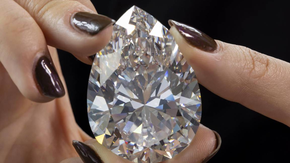 $!Un aempleada de Christie’s sostiene ‘The Rock’, el diamante blanco más grande jamás visto en la historia del mercado de subastas, en Ginebra, Suiza.