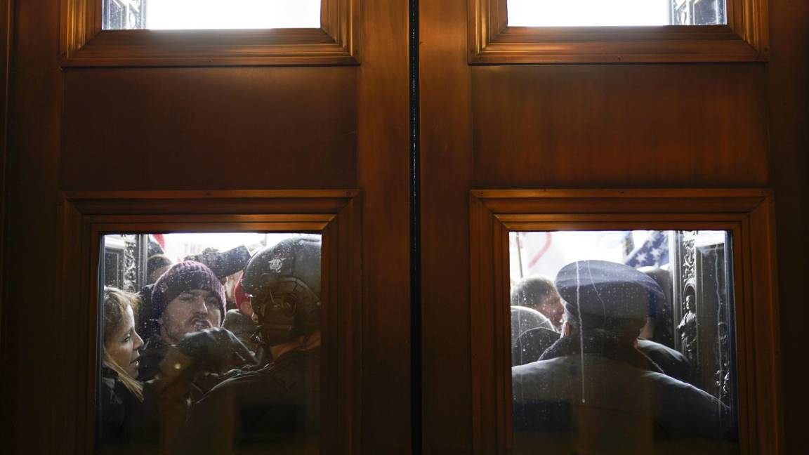 $!La Policía del Capitolio intenta contener a los alborotadores fuera de las puertas de la Cámara del Capitolio el 6 de enero de 2021. AP/Andrew Harnik