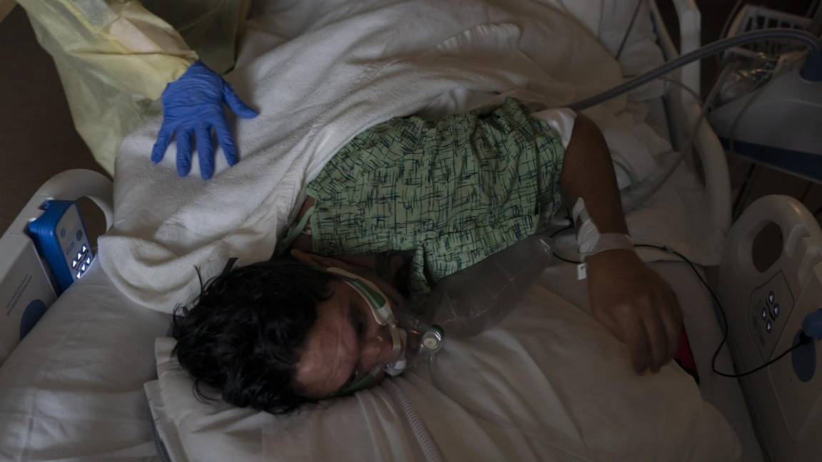 $!Un enfermero ayuda un paciente a cambiar de posición mientras lo trata en una unidad de COVID-19 en el Centro Médico Providence Holy Cross en Los Ángeles.