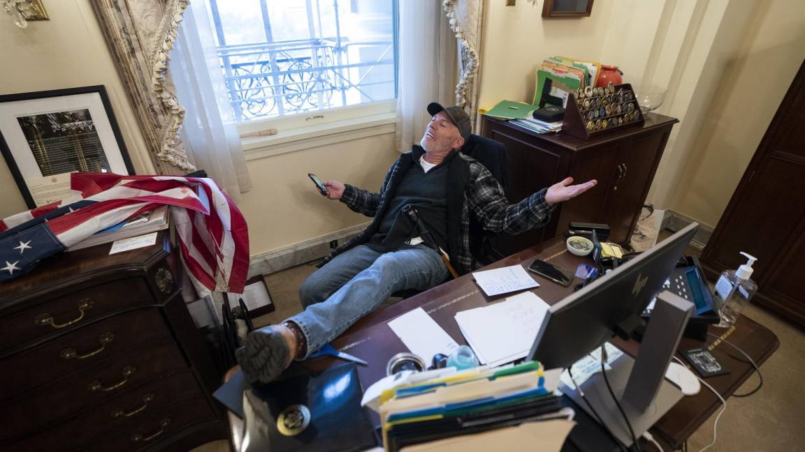 $!Un partidario del ex presidente de Donald Trump, se sienta en el escritorio de la presidenta de la Cámara de Representantes Nancy Pelosi. EFE/EPA/Jim Lo Scalzo