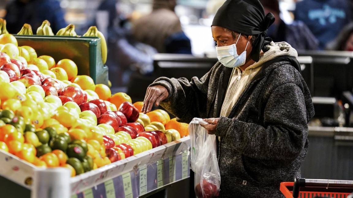 $!Una compradora con mascarilla selecciona frutas en el Reading Terminal Market en Filadelfia. AP/Matt Rourke
