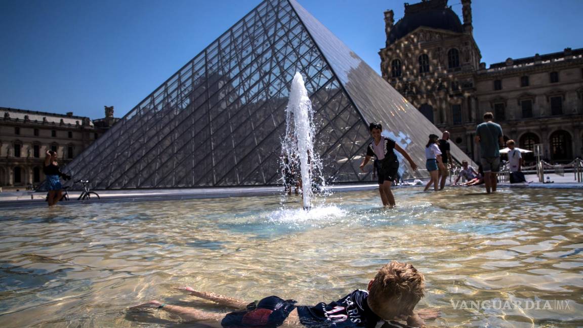 $!Parisinos y turistas se refrescan en las fuentes de la Pirámide del Museo del Louvre en París, Francia.