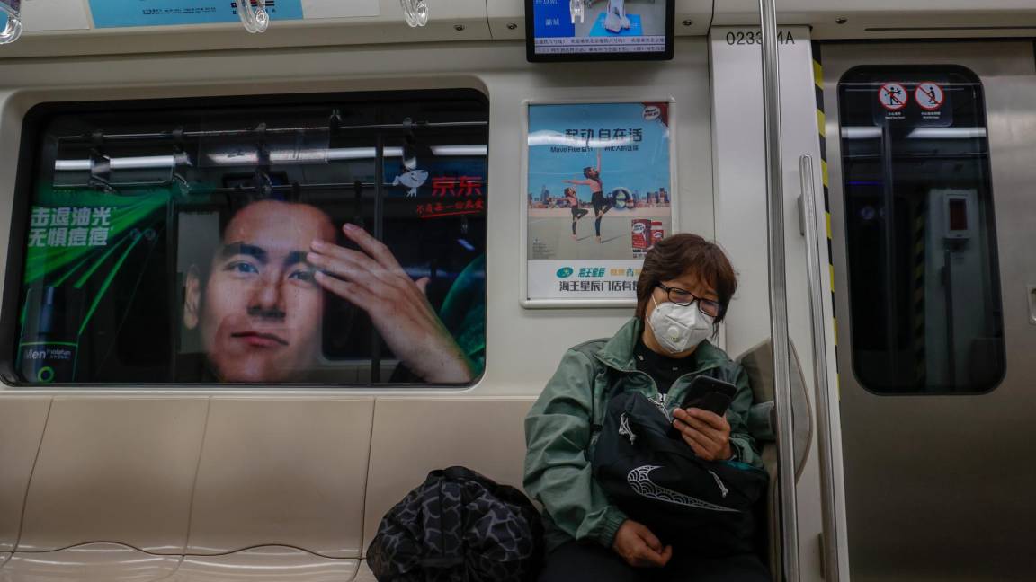 $!Una mujer usa su teléfono móvil dentro de un tren en Beijing, China.