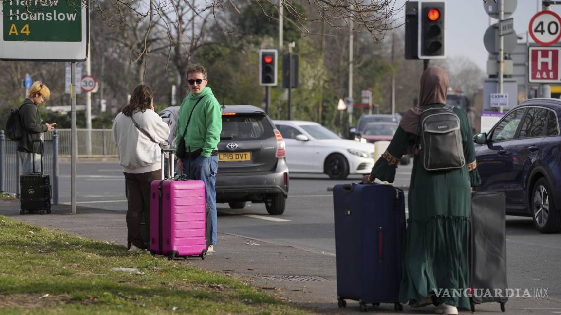 $!Pasajeros en una carretera cercana después de que el Aeropuerto Heathrow de Gran Bretaña cerrara afectando los vuelos de cientos de miles de pasajeros.