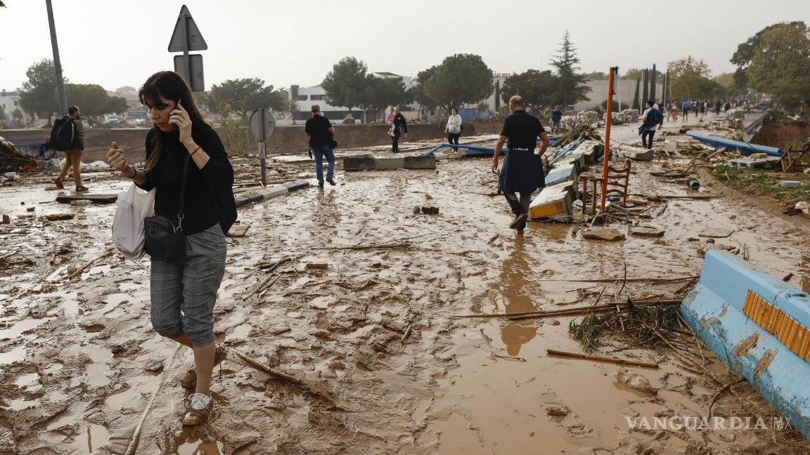 $!Una mujer camina entre el lodo acumulado por las intensas lluvias de la fuerte DANA en Picaña, Valencia.