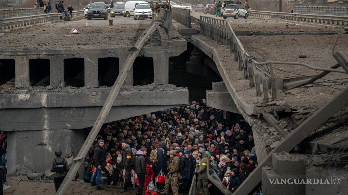 $!Ciudadanos ucranianos esperan debajo de un puente destruido mientras tratan de huir cruzando el río Irpin, en las afueras de Kiev, Ucrania, el 5 de marzo de 2022.