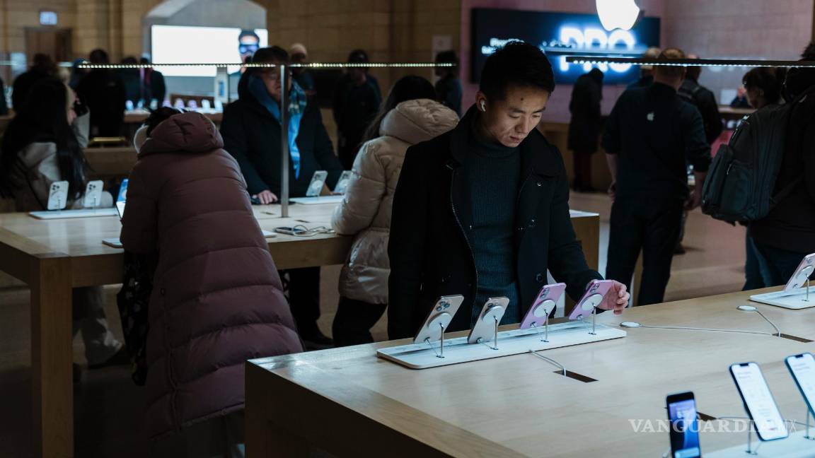 $!Un cliente examina el último modelo de iPhone en la Apple Store de Grand Central Terminal en Nueva York tras cuatro meses de su segundo mandato, hay indicios de que la economía comienza a sufrir mayores tensiones.