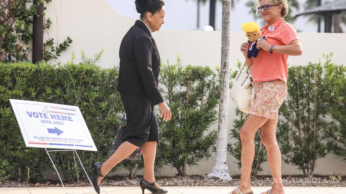 $!Kim Dryer (d) lleva un muñeco hecha a mano del candidato presidencial republicano Donald Trump afuera de un centro de votación en West Palm Beach.