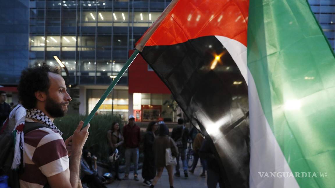 $!Un hombre sostiene una bandera de Palestina en una manifestación de apoyo a Palestina frente a la embajada de Israel en Bogotá, Colombia.