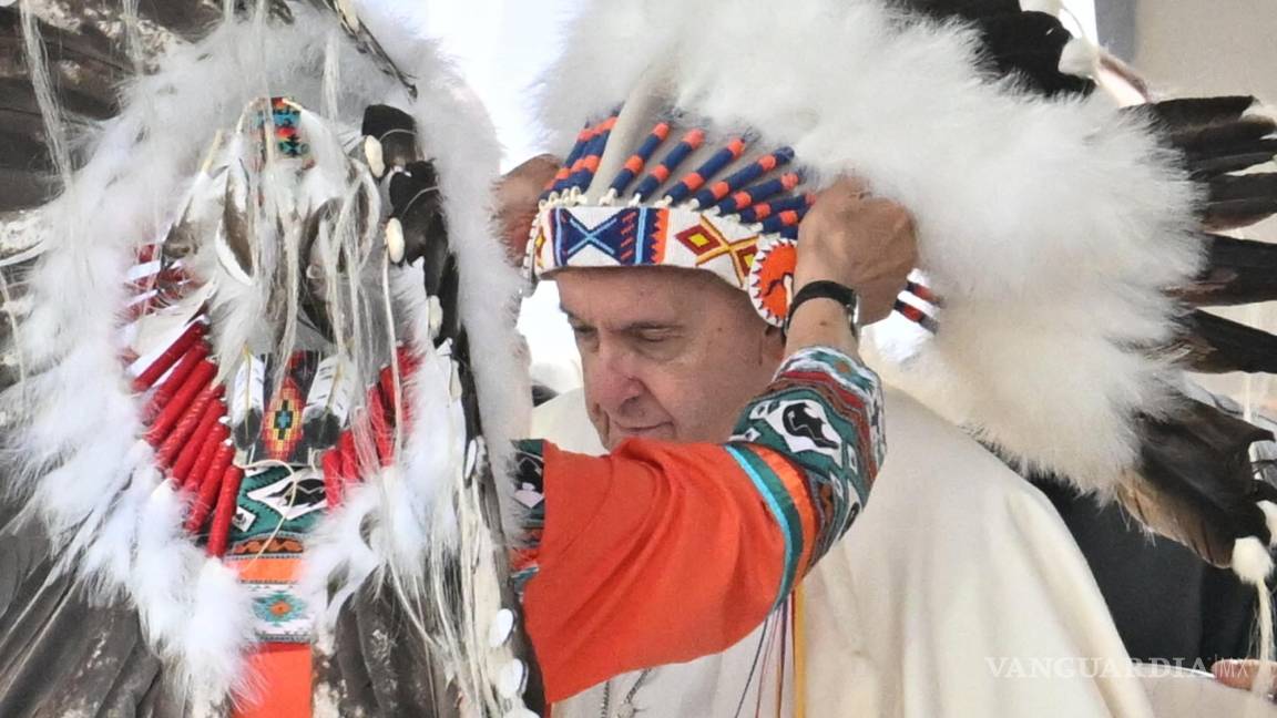 $!El Papa Francisco recibe un tocado indígena en una reunión con indígenas para una oración silenciosa en el cementerio de Maskacis en Edmonton, Canadá.