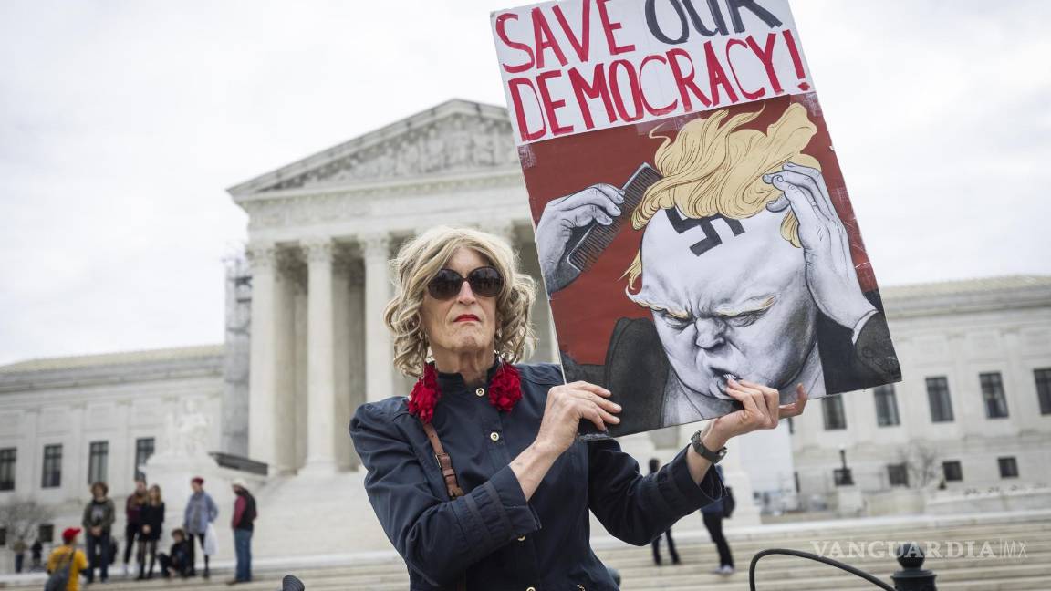 $!Un manifestante sostiene un cartel frente a la Corte Suprema donde los jueces superiores dictaminaron que rump aparezca en la boleta electoral de Colorado.
