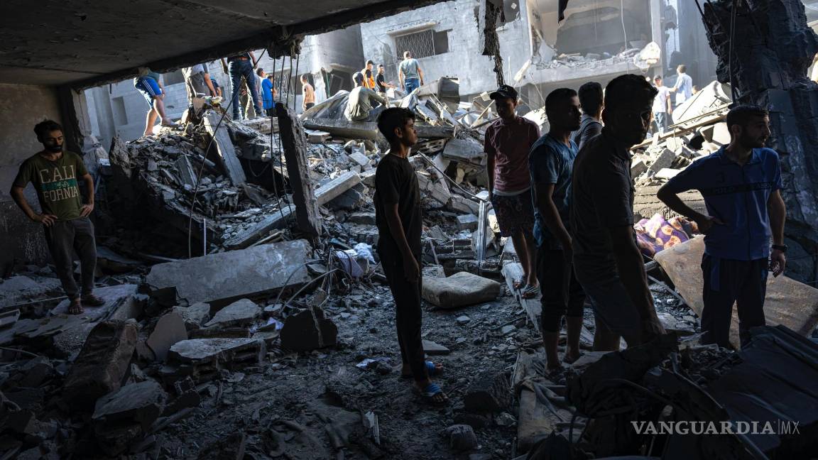 $!Palestinos buscan cadáveres y sobrevivientes entre los restos de un edificio residencial arrasado tras un ataque aéreo israelí sobre el campo de refugiados.