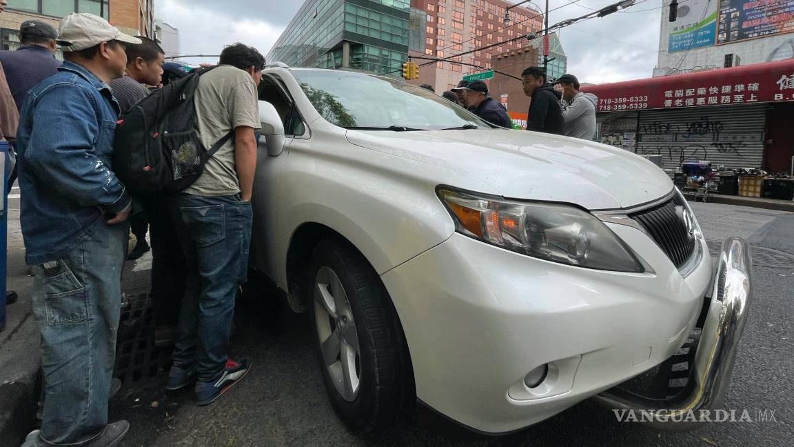 $!Wang Gang, de 36 años, centro izquierda, inmigrante chino, conversa con el conductor de un coche para conseguir un trabajo en el barrio de Flushing.