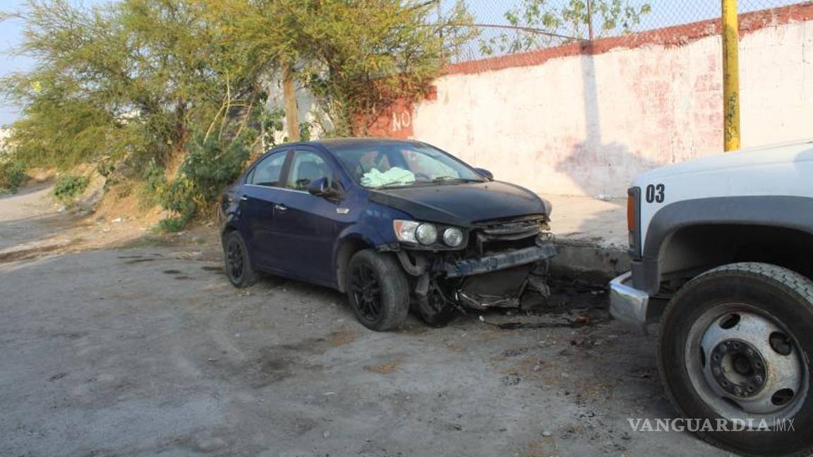 $!El automóvil Chevrolet Sonic terminó con severos daños en la parte frontal tras impactarse contra una banqueta y una barda.