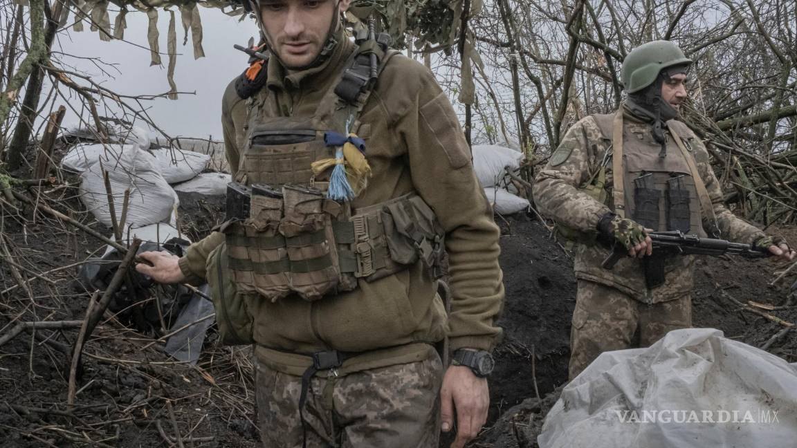 $!Los soldados ucranianos se mueven alrededor de la trinchera mientras observan el horizonte donde están estacionadas las tropas rusas en Bakhmut, Ucrania.