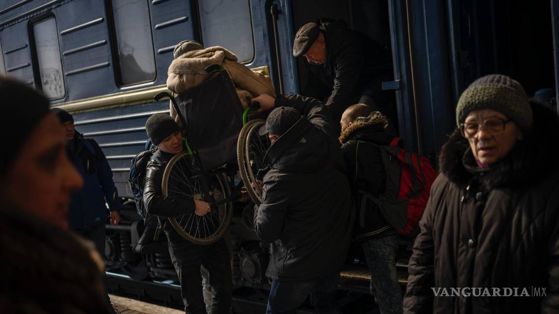 $!Ucranianos que huyeron de la sitiada ciudad de Mariúpol y otros pasajeros procedentes de Zaporiyia llegan a Leópolis, en Ucrania, el 20 de marzo de 2022.