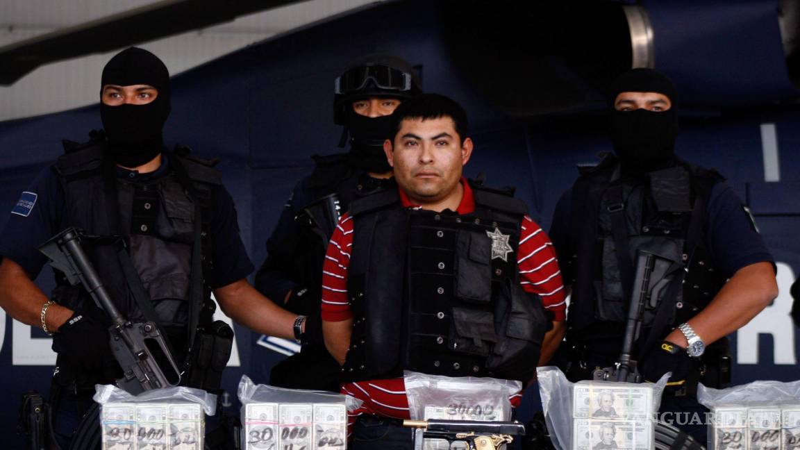 $!MÉXICO, D.F., 07NOVIEMBRE2008.- Jaime González Durán alias El Hummer presunto líder y fundador de los Zetas fue detenido en Reynosa, Tamaulipas, por elementos de la Policía Federeral, por la tarde llegó al aeropuerto de la PFP y fue presentado a los medios de la comunicación junto con armas y dolares. FOTO: EDUARDO JIMENEZ/CUARTOSCURO.COM