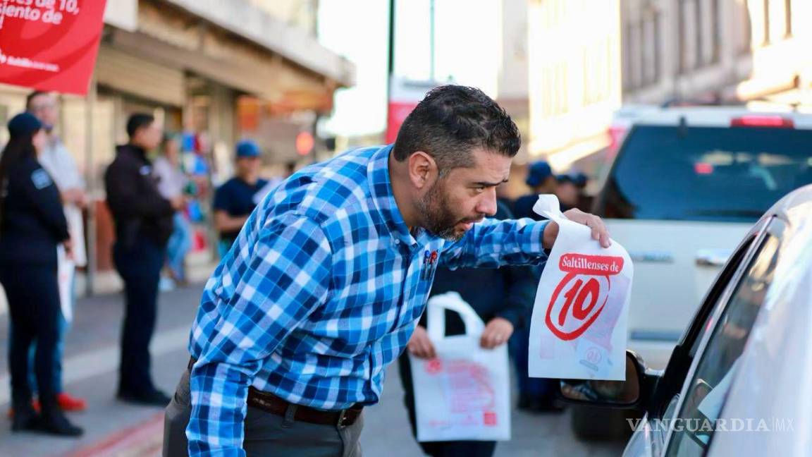 $!Ciudadanos observan carteles informativos sobre las reglas de tránsito mientras transitan por el centro de Saltillo.