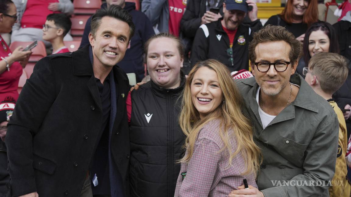 $!Los codueños de Wrexham Ryan Reynolds (derecha), su esposa Blake Lively (segunda derecha) y Rob McElhenney (izquierda) posan con hinchas.