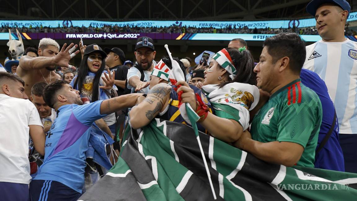 ¡Y el juego aún no empieza! Aficionados de Argentina y México forcejearon en las gradas por una bandera