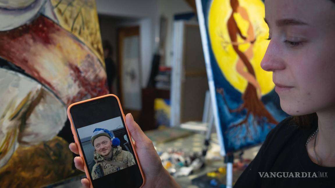 $!Olesia Skalska muestra una foto de su esposo Roman Skalskyi, quien murió en batalla con las tropas rusas, en un estudio en Kiev, Ucrania.