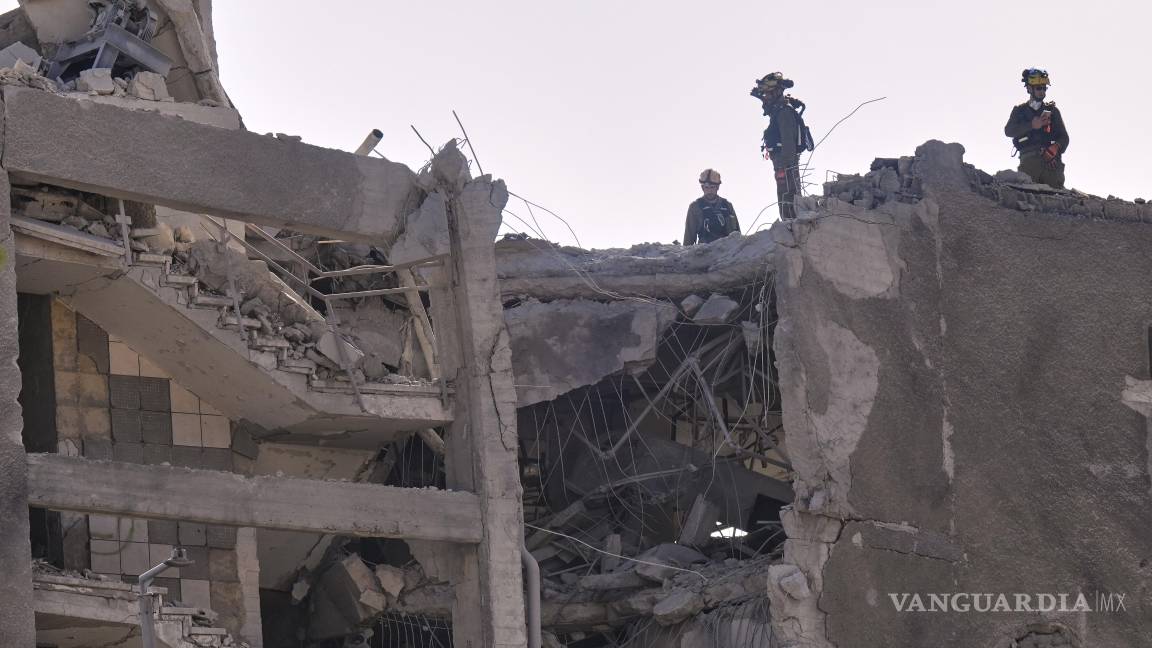 $!Las unidades de comando del frente interno israelí trabajan en un edificio dañado después de que fuera alcanzado por un misil disparado desde Irán, en Haifa, Israel.