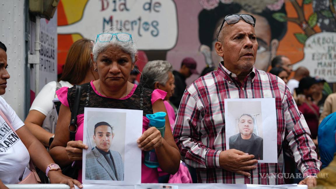 $!Personas con fotografías de parientes migrantes, de los que dicen fueron detenidos en EU y aguardan a ser deportados, protestan en Caracas.