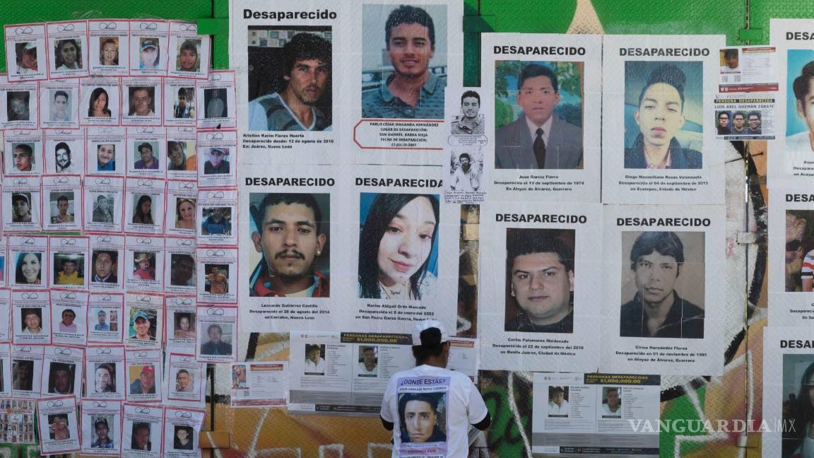 $!Una persona mira fotos de personas en la Glorieta de las y los Desaparecidos en CDMX.