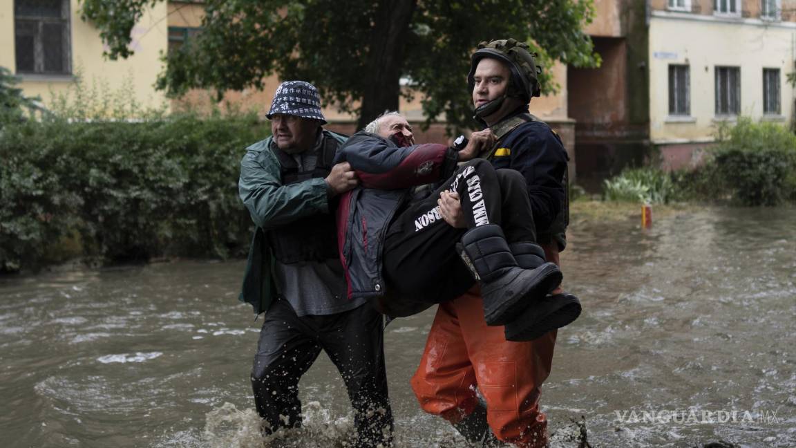 $!Equipos de rescate ayudan a trasladar a zona segura a un hombre que fue atacado por las fuerzas rusas mientras intentaba huir por barco de la inundada orilla oriental ocupada por Rusia del río Dniéper a Jersón, controlada por Ucrania, en la orilla occidental en Jersón, Ucrania, el domingo 11 de junio de 2011. (AP Foto)
