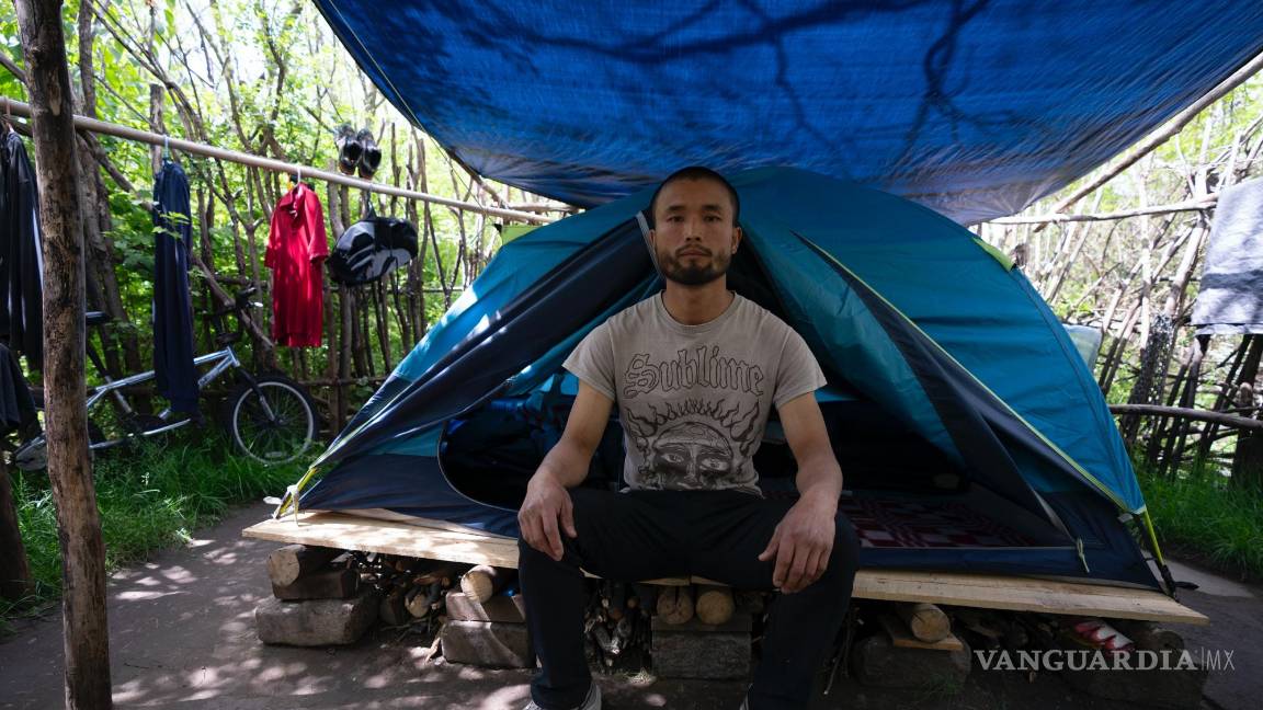 $!Chen Wang, un migrante chino actualmente sin hogar en Nueva York, posa para una fotografía frente a su tienda.