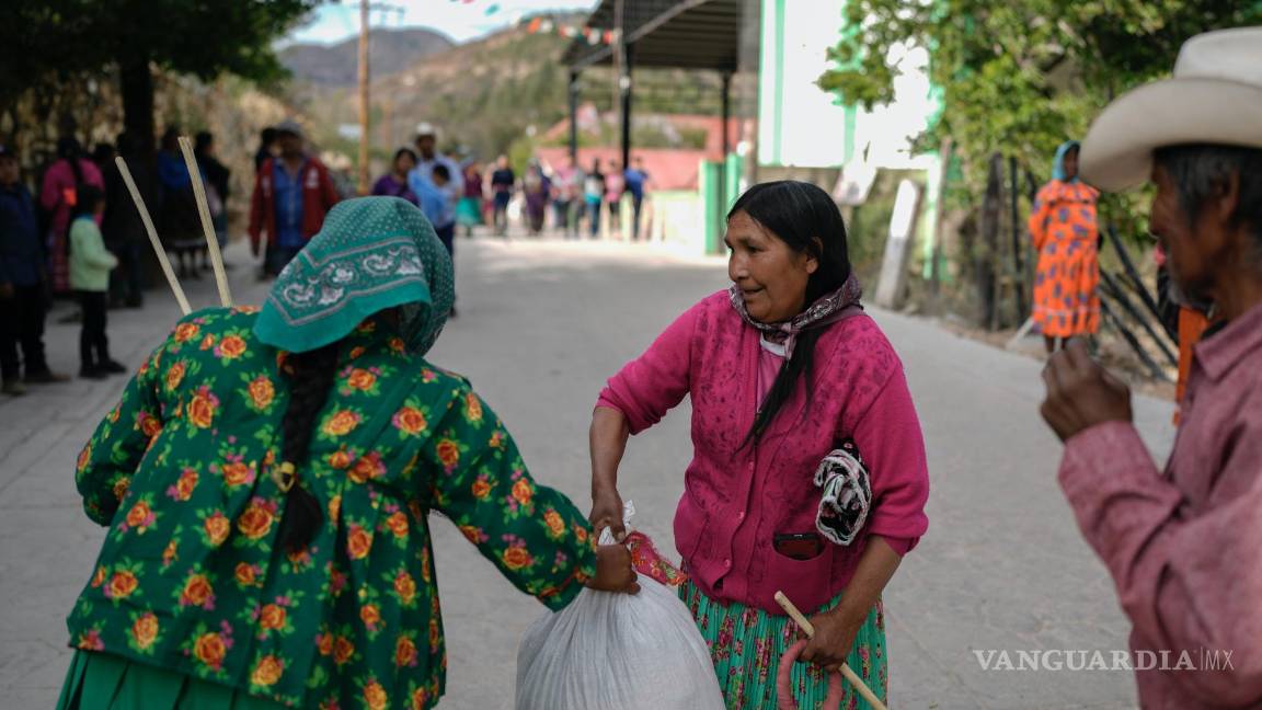 $!Una mujer rarámuri, a la izquierda, que representa al equipo en la competencia de carreras de Arihueta, recoge sus ganancias del representante del equipo contrario.