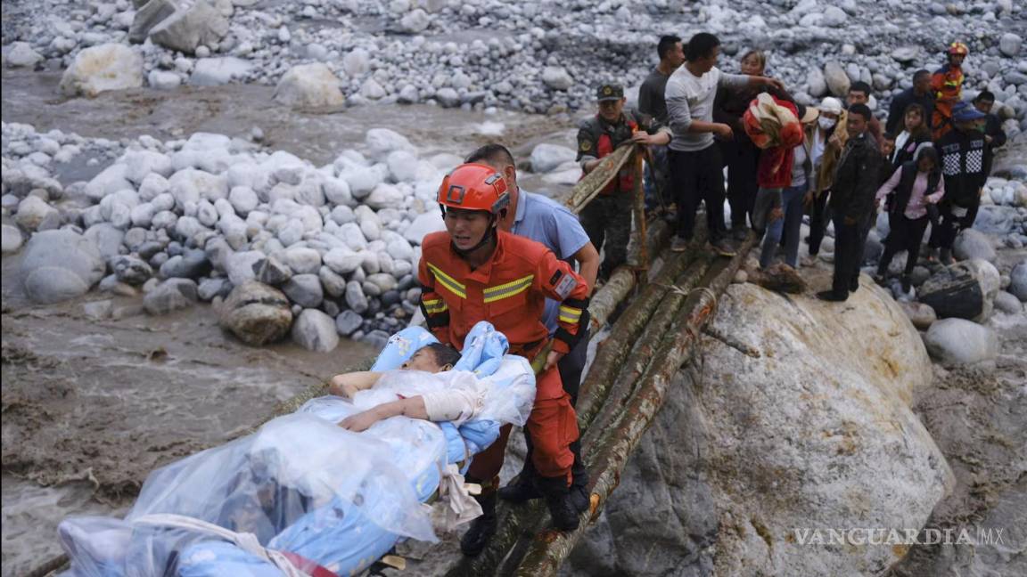 $!Rescatistas trasladan a los sobrevivientes a través de un río luego de un terremoto en la ciudad de Moxi del condado de Luding, en la provincia de Sichuan.