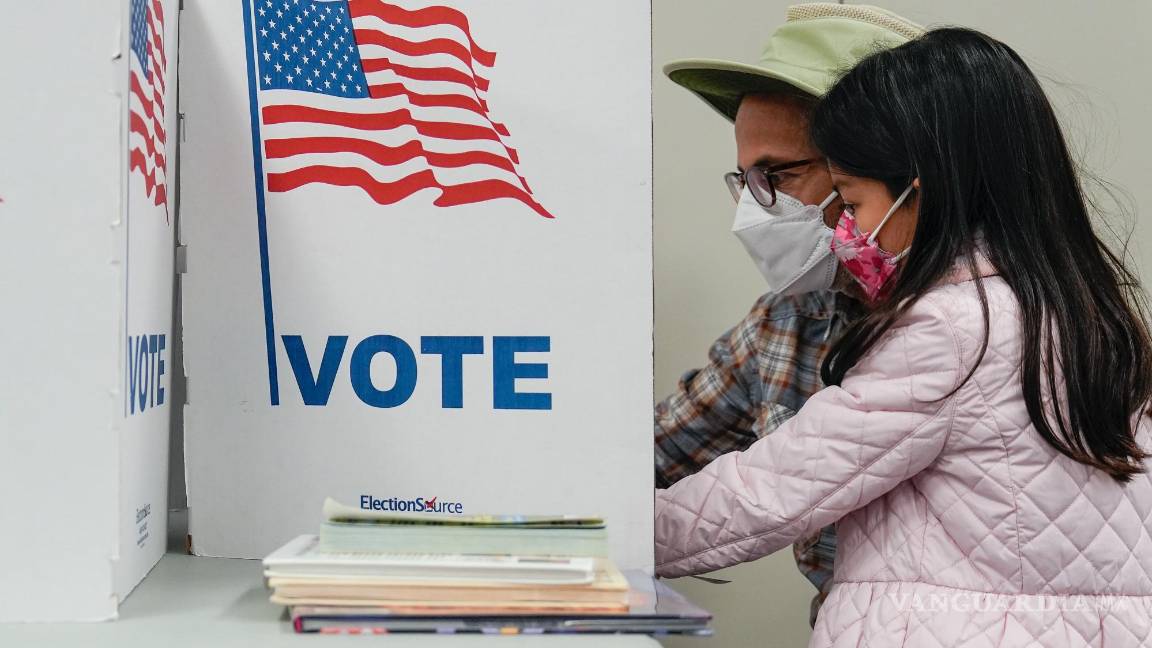 $!Una persona marca su boleta mientras su hijo observa en el lugar de votación en la Biblioteca Regional Tysons-Pimmit en Falls Church, Virginia.