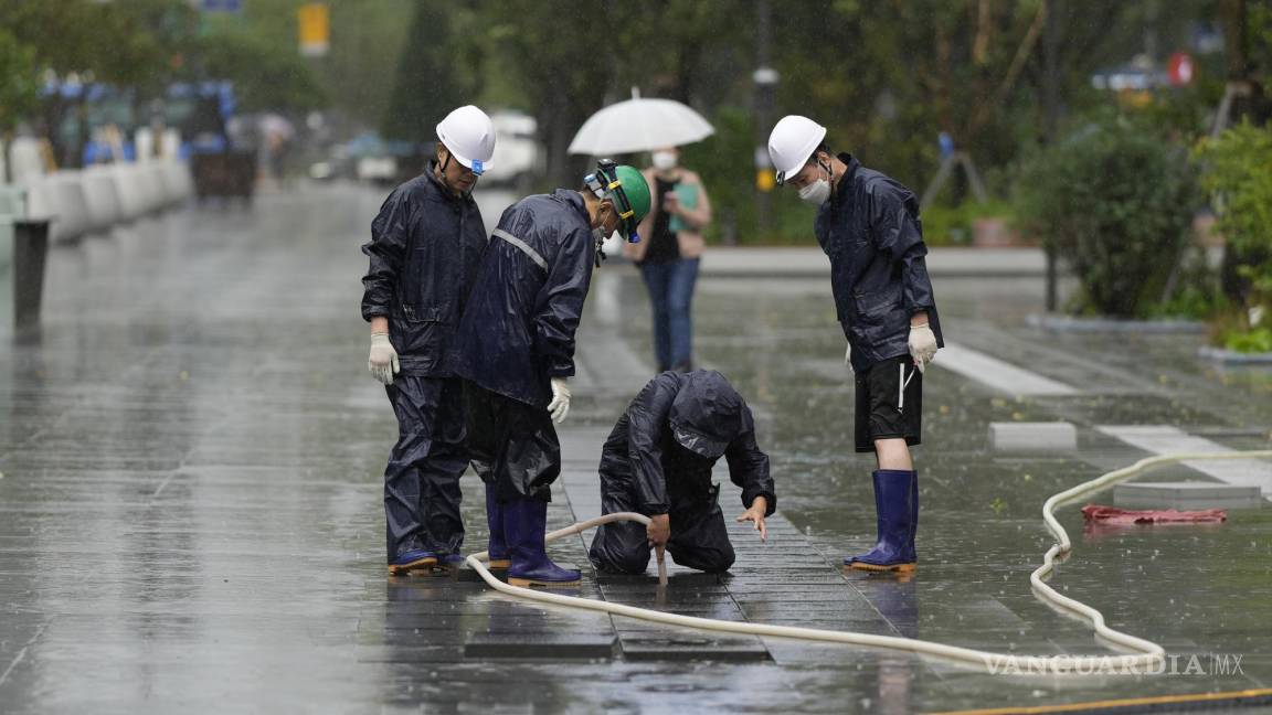$!Los trabajadores revisan el orificio de drenaje en una plaza mientras el tifón Hinnamnor viaja hacia la península de Corea en Seúl, Corea del Sur.
