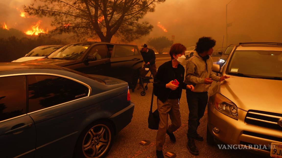 $!La gente huye del avance del incendio Palisades, en automóvil y a pie, en el vecindario Pacific Palisades de Los Ángeles.