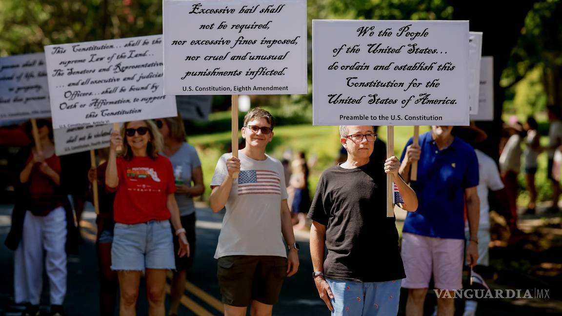 $!Personas muestran secciones de la Constitución estadounidense en protesta en el desfile del 4 de julio en Georgia.